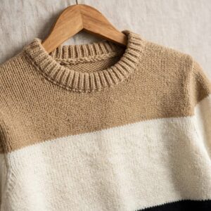 Men's color-block knit sweater in camel cream and black on hanger